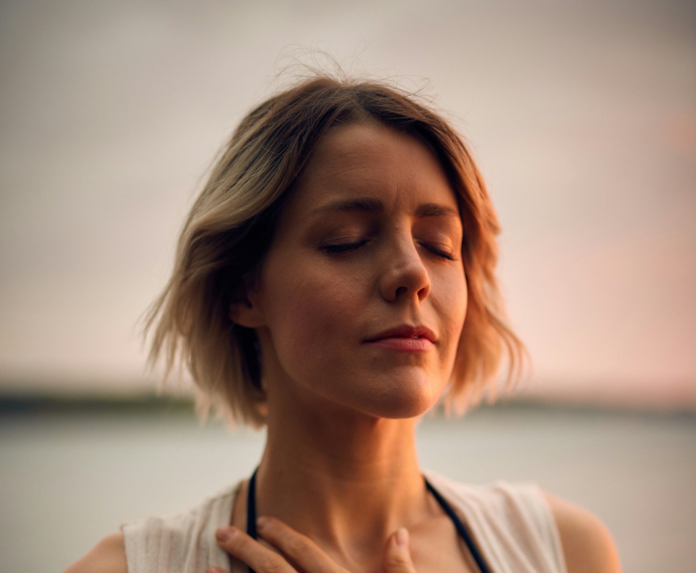 Woman with hand on chest, peaceful expression